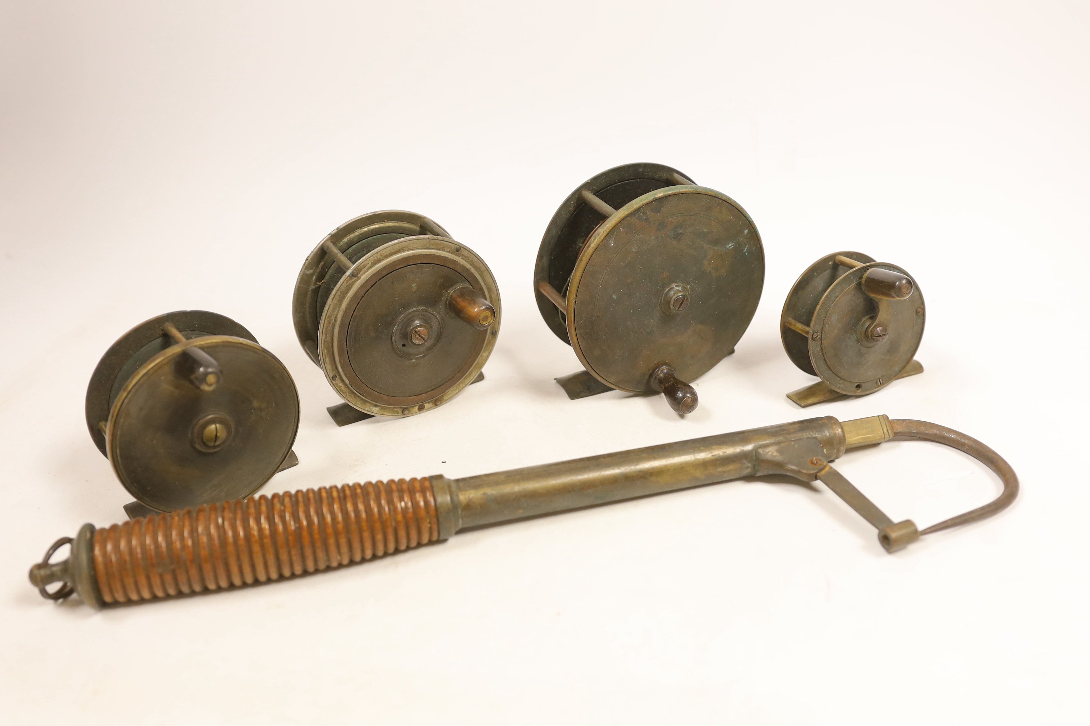 Four various sized fishing reels and a hook